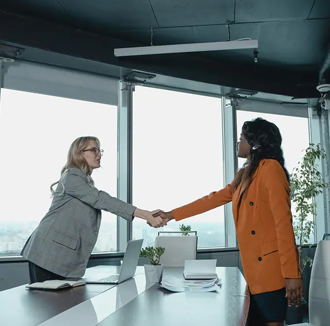 Two female professionals shaking hands